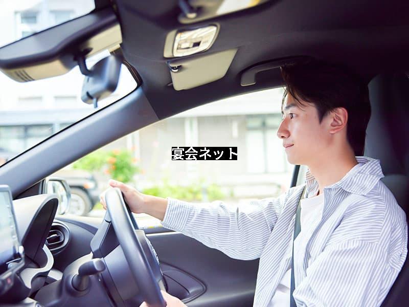 車で宿泊先へ向かう男性