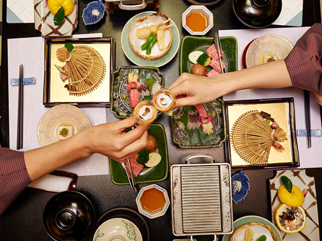 会席料理を目の前に乾杯をする様子