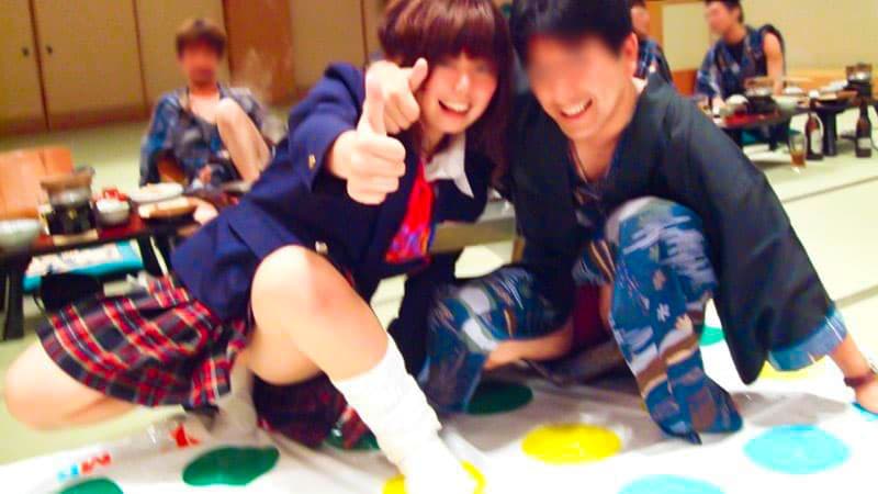 制服を着たコンパニオンとツイスターゲームを楽しむ男性