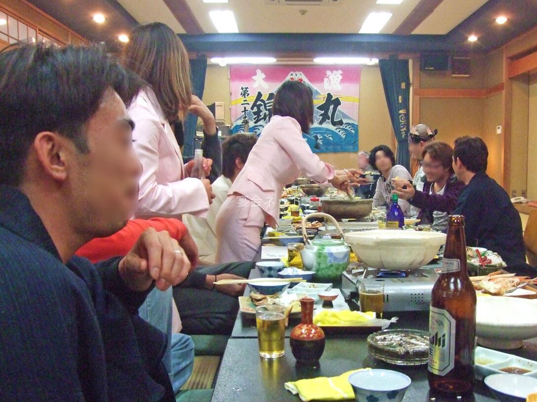 宴会でコンパニオンがお酒を注ぐ