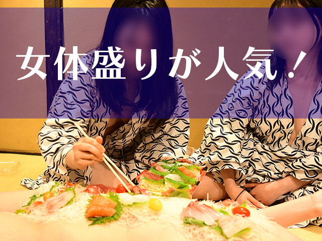 女体盛りのために刺し身を盛り付けるスーパーコンパニオン