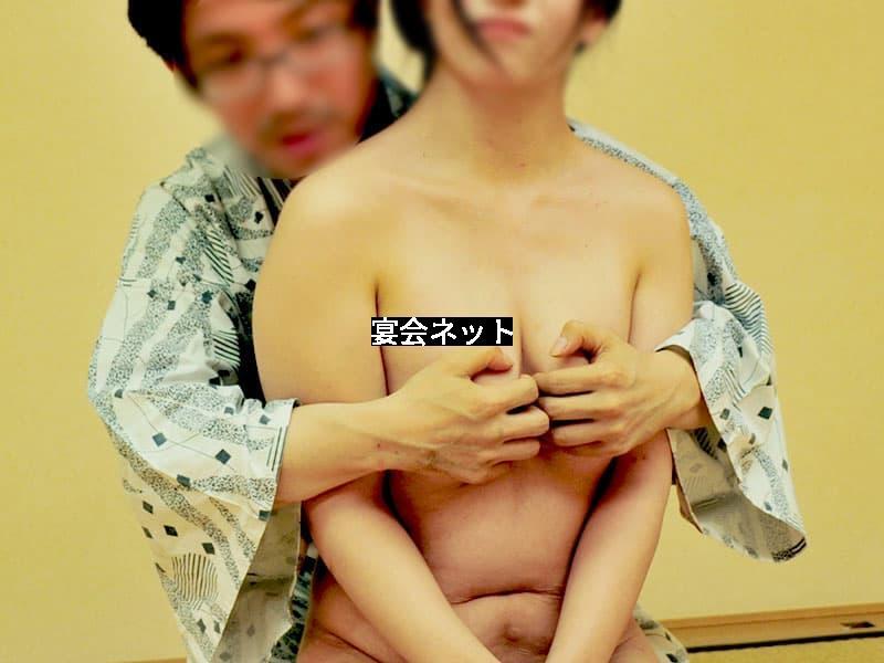 コンパニオンの胸を後ろから触る男性