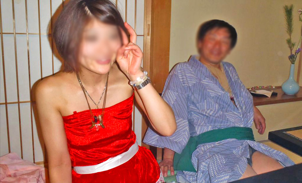 華やかな赤のドレスを着て微笑む女性を見る男性