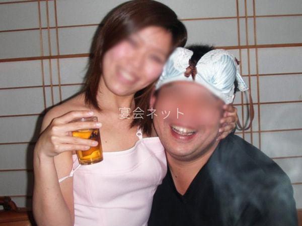 コンパニオンに抱きつく楽しそうな男性