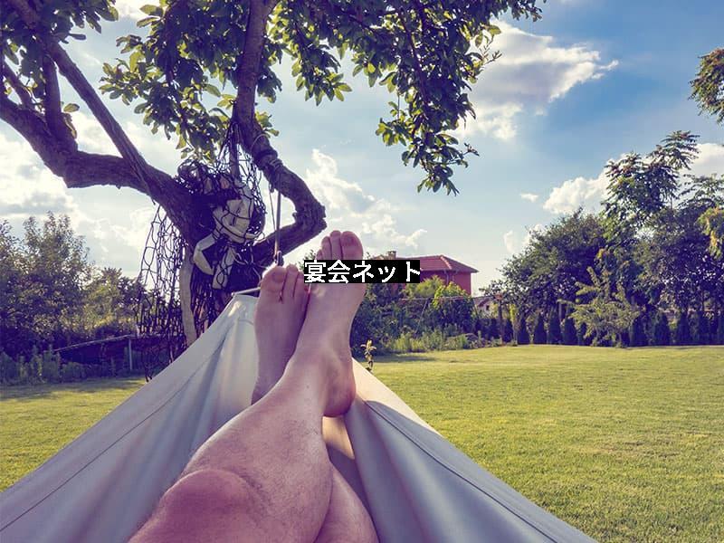 ハンモックに揺れてリラックスする男性