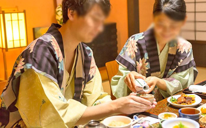 男性にお酌をする女性