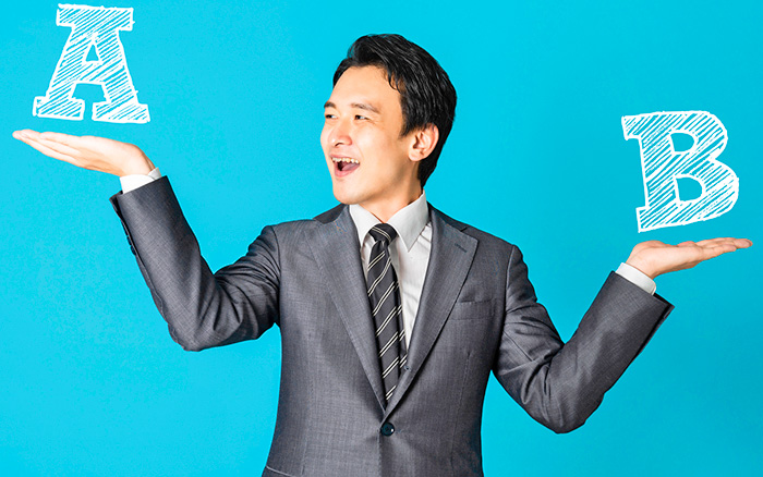 どっち？というポーズをする男性